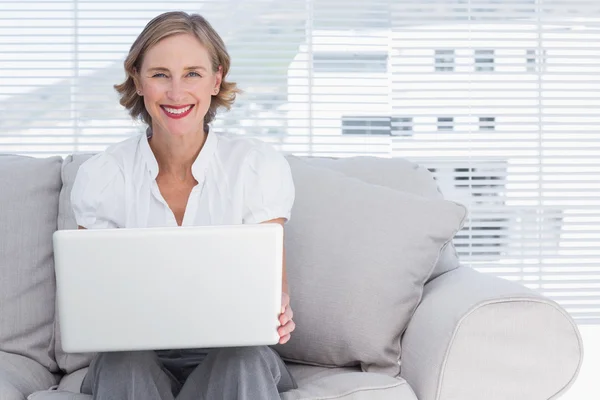 Empresária sorridente usando um laptop — Fotografia de Stock