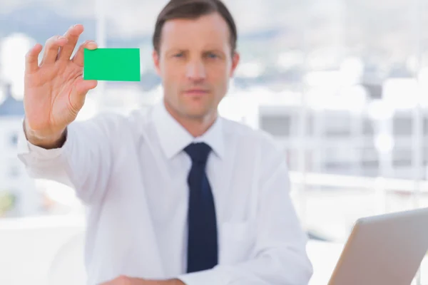 ビジネスマンの緑のビジネス カードを持っています。 — ストック写真