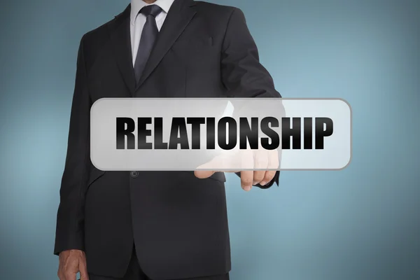 Empresário selecionando a palavra relacionamento escrito na etiqueta branca — Fotografia de Stock