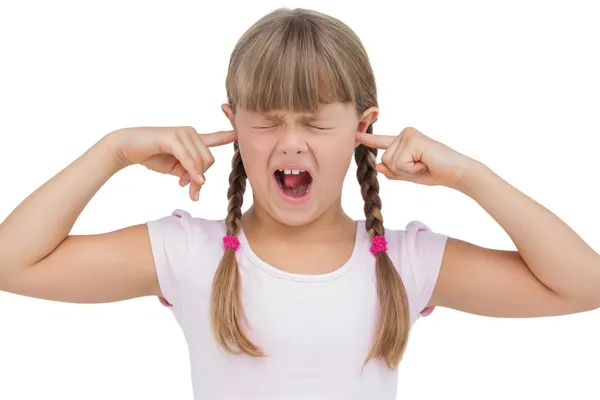 Divertente bambina intasando le orecchie e strizzando — Foto Stock