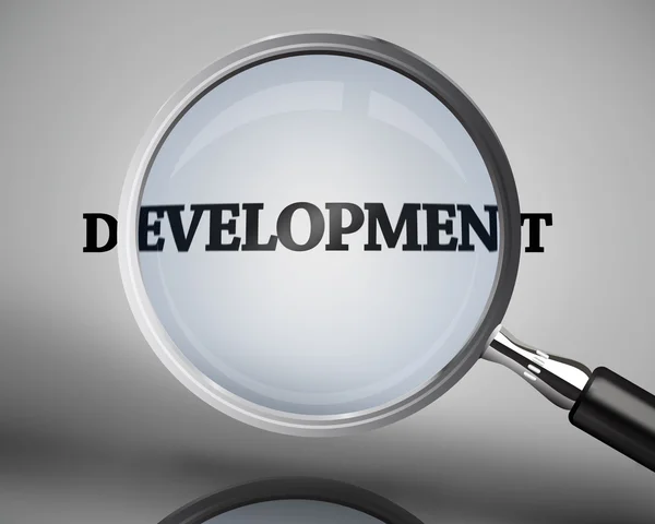 Magnifying glass showing development word — 图库照片