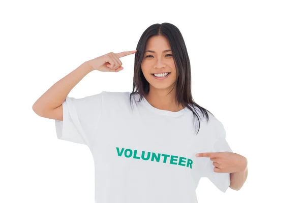 Femme souriante pointant son t-shirt bénévole — Photo