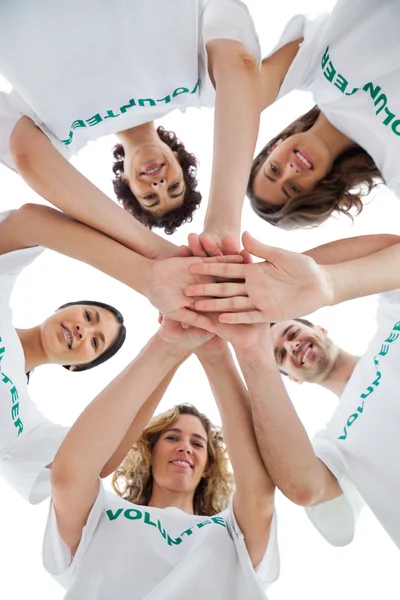 Uśmiechający się grupa wolontariuszy piętrzą się ręce — Zdjęcie stockowe
