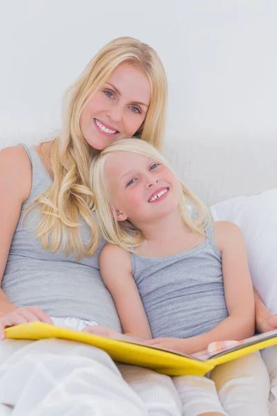 Mãe segurando um livro de história com sua filha — Fotografia de Stock