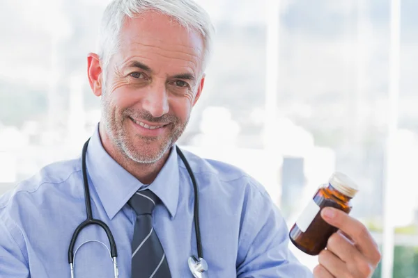 Médico sorridente segurando frasco medicina — Fotografia de Stock