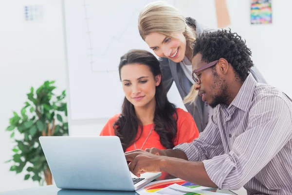 Drie ontwerpers samen te werken op een laptop — Stockfoto