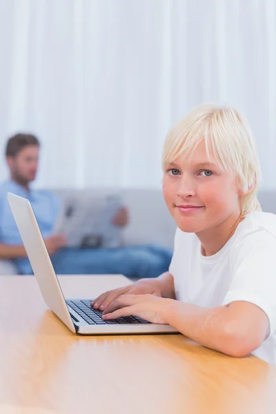 Küçük çocuk oturma odasında dizüstü bilgisayarda yazarak — Stok fotoğraf