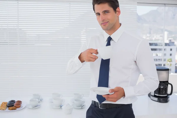 Lachende zakenman met een kopje koffie tijdens de pauze — Stockfoto