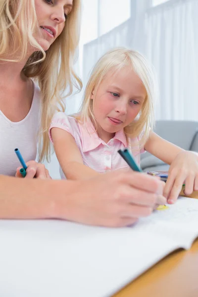 Mother and daughter drawing at the table Stock Photo