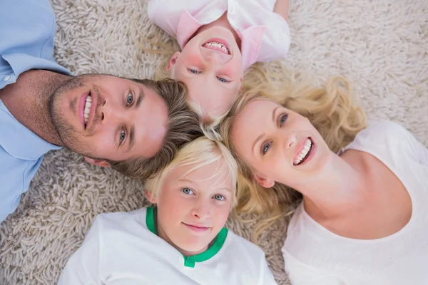 Overhead of family lying on the carpet — Stock Photo, Image