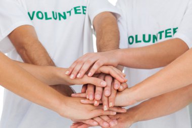 Volunteers piling up their hands together clipart