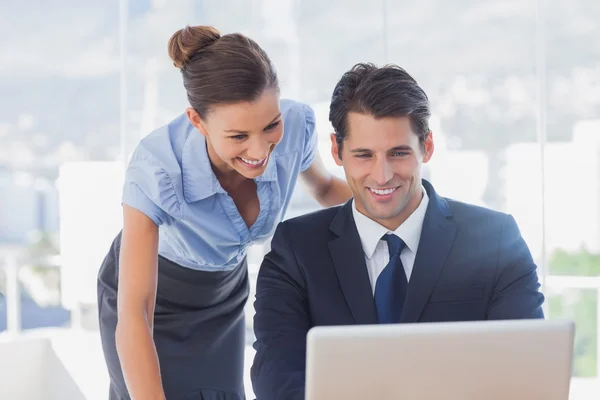 Happy business looking at laptop and smiling — Stock Photo, Image