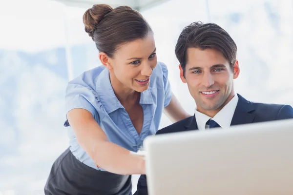 Happy business looking together at the laptop — Stock Photo, Image