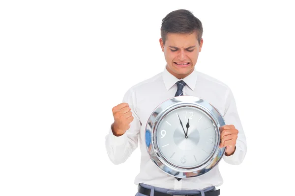 Тревожный бизнесмен держит и смотрит на часы — стоковое фото