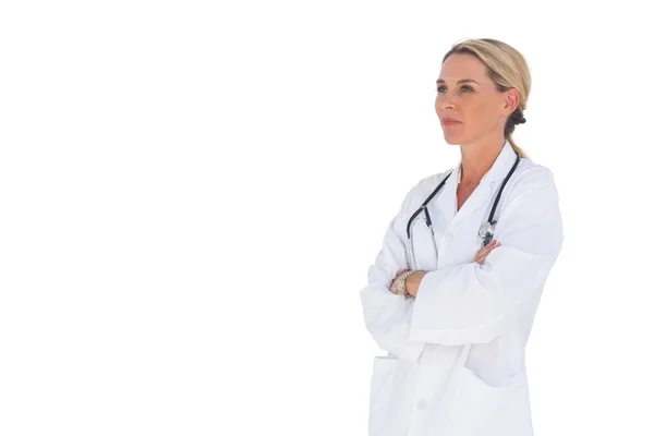 Doctor with arms crossed looking upwards — Stock Photo, Image