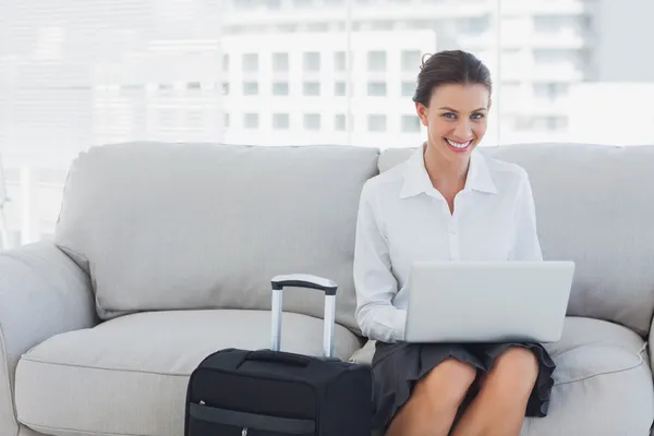 Mujer de negocios feliz sentado en el sofá usando el ordenador portátil —  Fotos de Stock