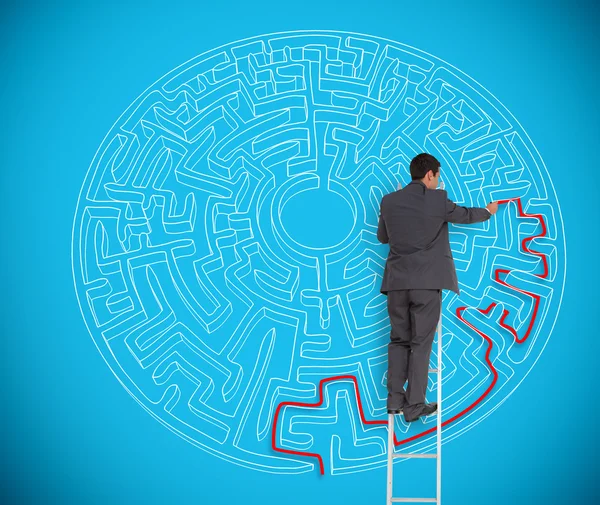 Businessman drawing red line to solve a complex maze — Stock Photo, Image