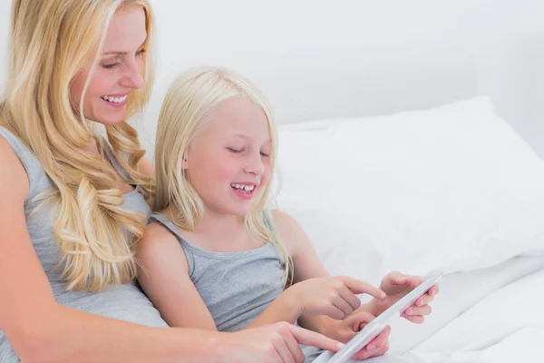 Alegre madre e hija usando una tableta —  Fotos de Stock