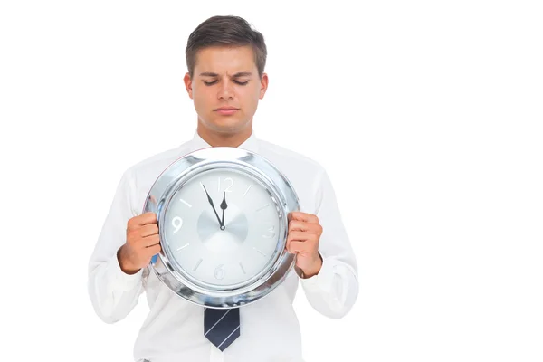 Businessman holding and looking at clock — Zdjęcie stockowe