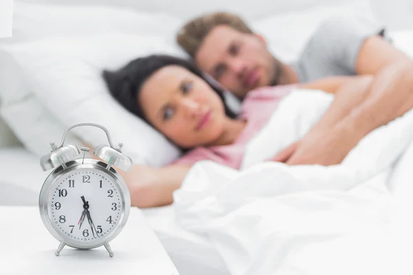 Tired couple looking at the alarm clock — Stock Photo, Image