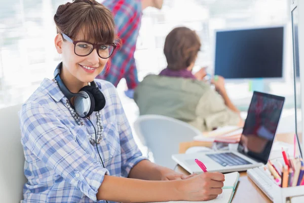 Portrait of an attractive designer writing on a notepad — Stock Photo, Image