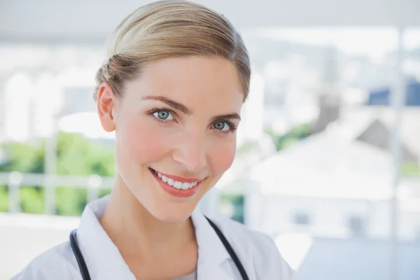 Médico sonriente de pie en su consultorio — Foto de Stock