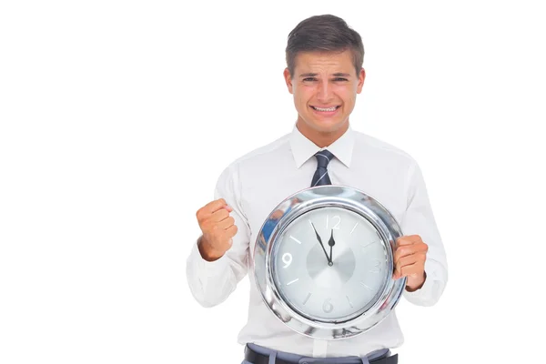 Fearful businessman holding and looking at clock — Stock Photo, Image