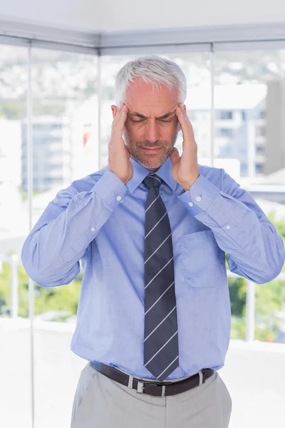 Stressed businessman rubbing his temples with eyes closed — Stock Photo, Image