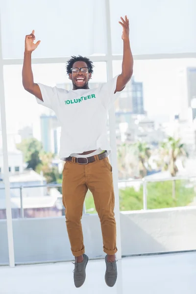 Homem pulando com tshirt voluntária, em seguida, levantando os braços — Fotografia de Stock