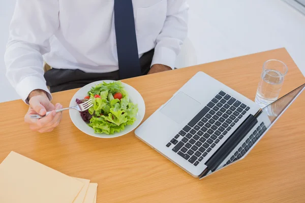 Overhead of a businessman eating a salad on his desk — Stock Photo, Image