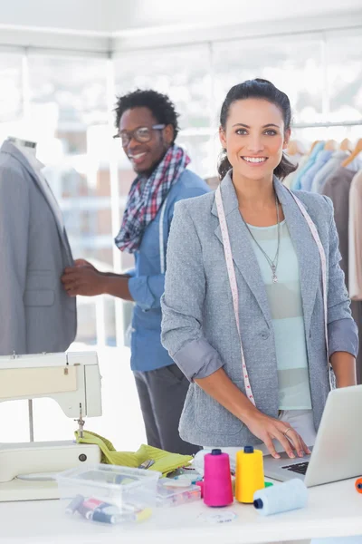 Team von Modedesignern arbeitet und lächelt in die Kamera — Stockfoto