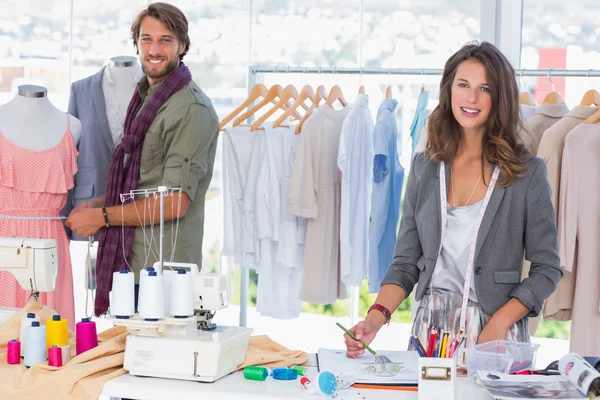 Fashion designers working and smiling at camera — Stock Photo, Image