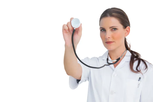 Stern nurse holding up stethoscope — Stock Photo, Image