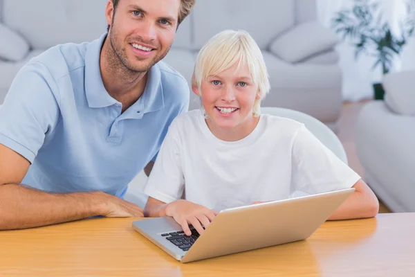 Usměvavý otec a jeho syn pomocí přenosného počítače — Stock fotografie