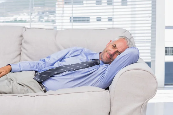 Businessman lying on sofa resting — Stock Photo, Image