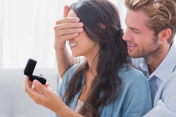Hombre escondiendo sus ojos esposas para ofrecerle un anillo de compromiso —  Fotos de Stock