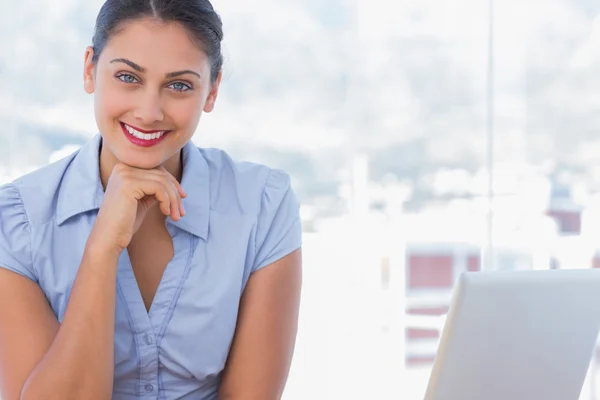 Empresária feliz sentada em sua mesa — Fotografia de Stock