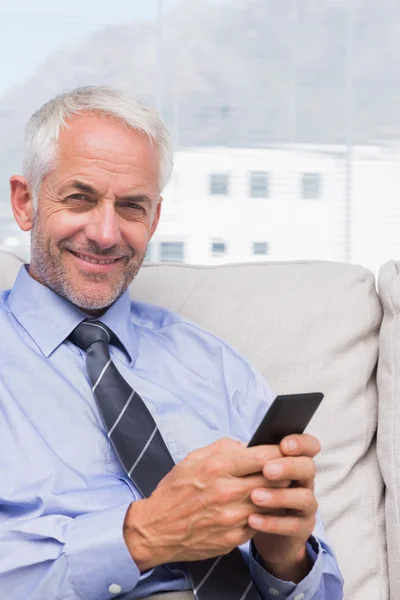 Usmívající se podnikatel pomocí smartphonu — Stock fotografie