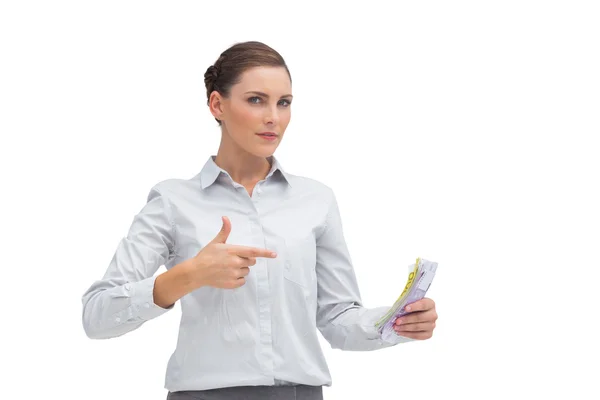 Businesswoman pointing to money in her hand — Stock Photo, Image