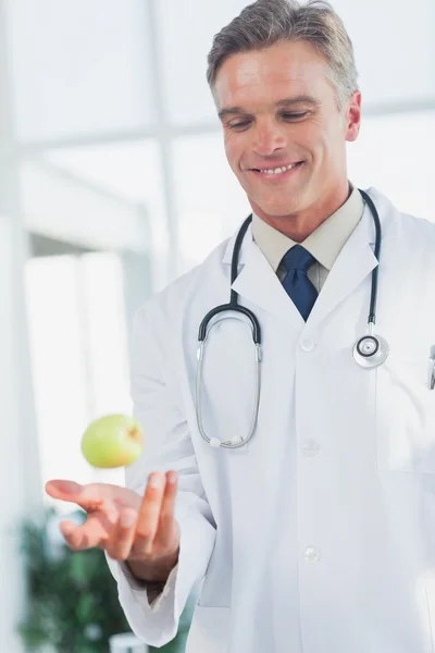 Doctor lanzando una manzana — Foto de Stock