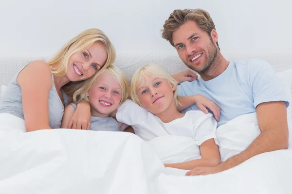 Retrato de uma família na cama — Fotografia de Stock