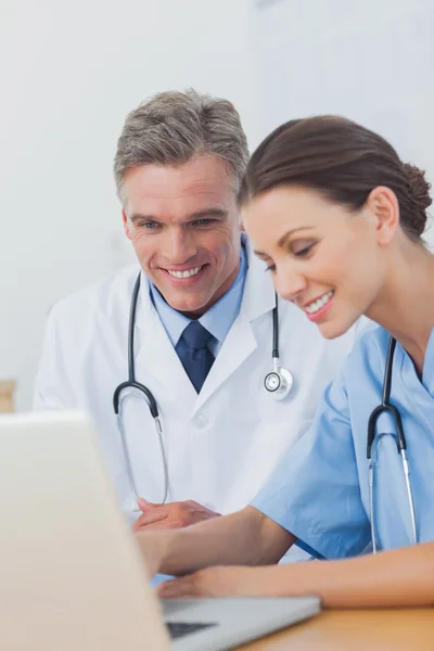 Two cheerful doctors working on a laptop — Stock Photo, Image