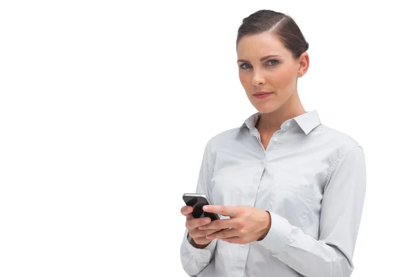 Mujer de negocios sin sonrisa sosteniendo el teléfono celular — Foto de Stock