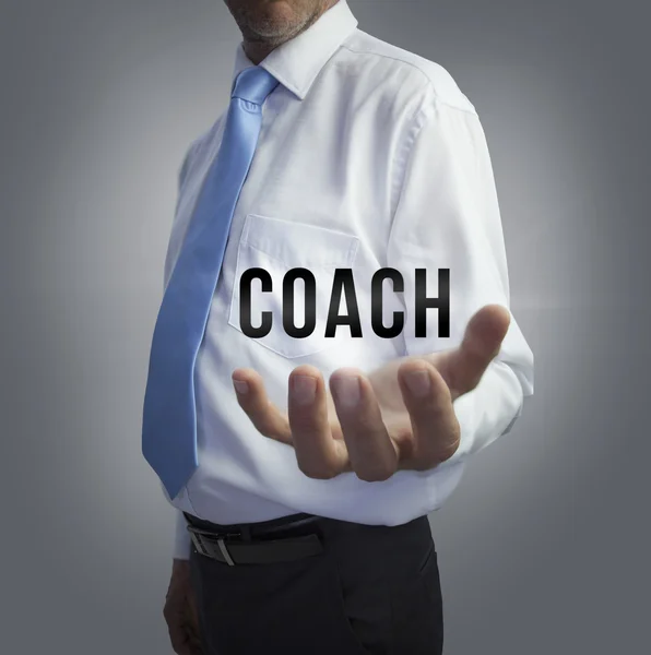 Homme d'affaires tenant le mot coach — Photo