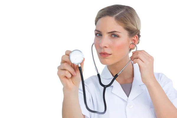 Enfermeira séria ouvindo com estetoscópio — Fotografia de Stock