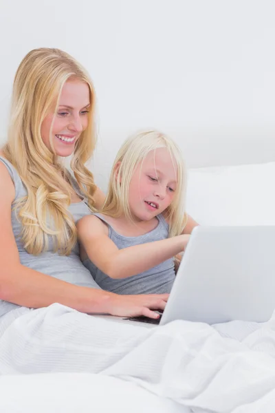 Mamá y su hija usando una computadora portátil — Foto de Stock