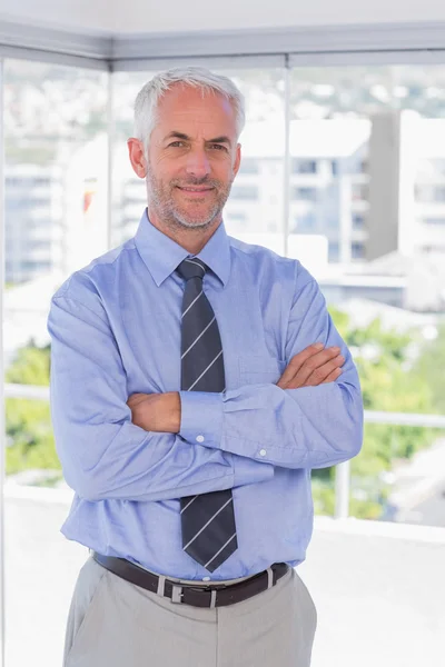 Empresário sorrindo de braços cruzados — Fotografia de Stock