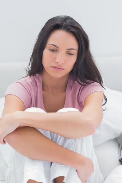 Anxious woman sat on her bed â Stock Photo