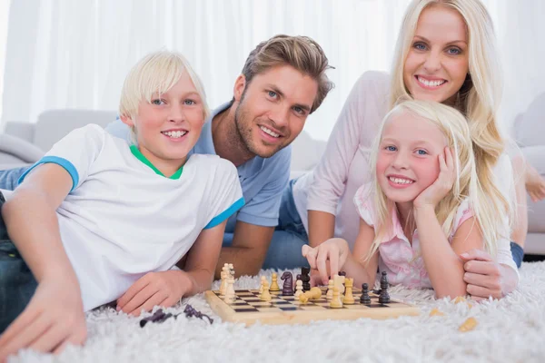 Улыбающаяся семья играет в шахматы вместе — стоковое фото