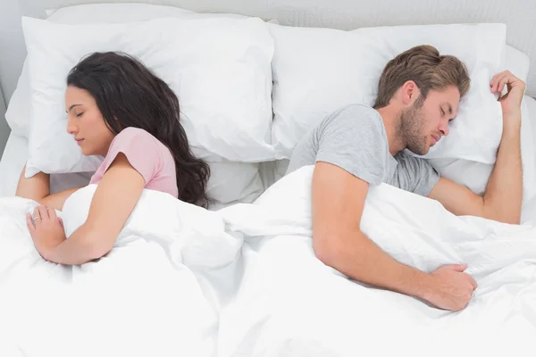 Casal dormindo de volta para trás em sua cama — Fotografia de Stock